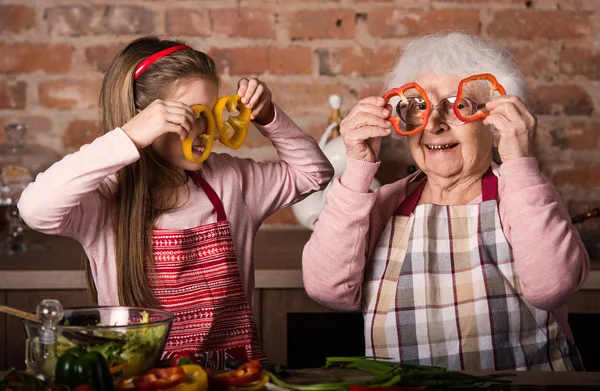 Vnuka s babičkou drží plátky papriky — Stock fotografie
