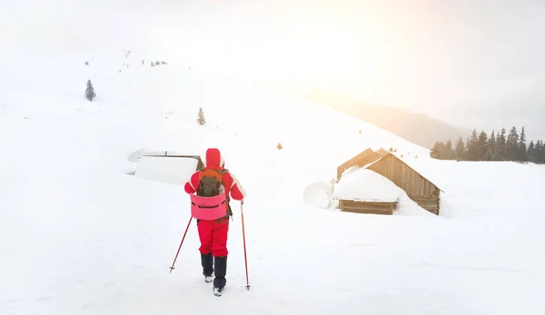 Escursionisti che vanno in una vecchia capanna coperta di neve — Foto Stock