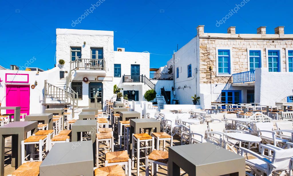 Typical Greek taverna with colored tables and chairs in Naoussa port