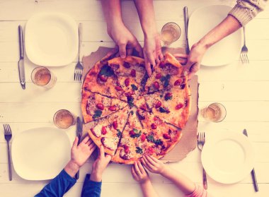 Eller pizza parçalarını alıyor.