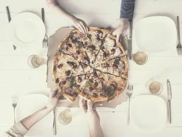 Four hands taking pieces of pizza — Stock Photo, Image