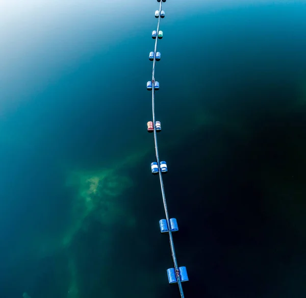 Aerial view of blue tube with barrels on the lake — Stock Photo, Image
