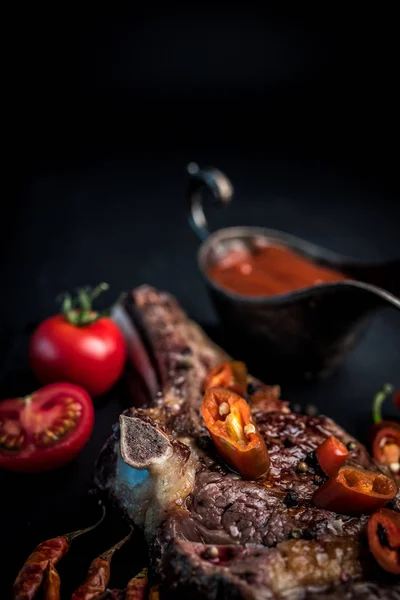 Filete de ternera a la parrilla con ribeye caliente en hueso con salsa picante —  Fotos de Stock