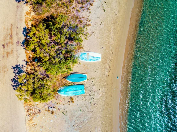 Barcos a remo deitados de cabeça para baixo numa praia à beira-mar — Fotografia de Stock