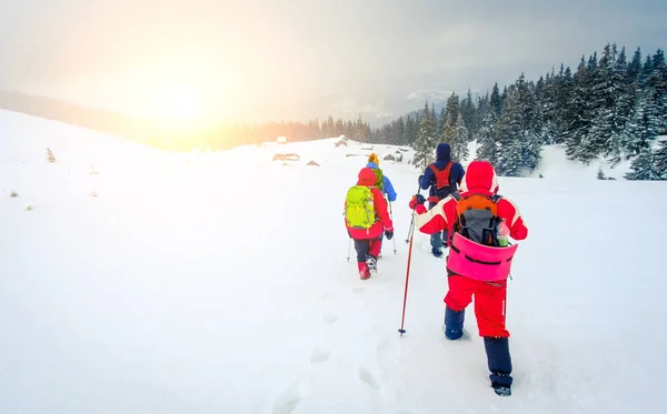 Senderistas que van hacia cabañas de montaña cubiertas de nieve — Foto de Stock