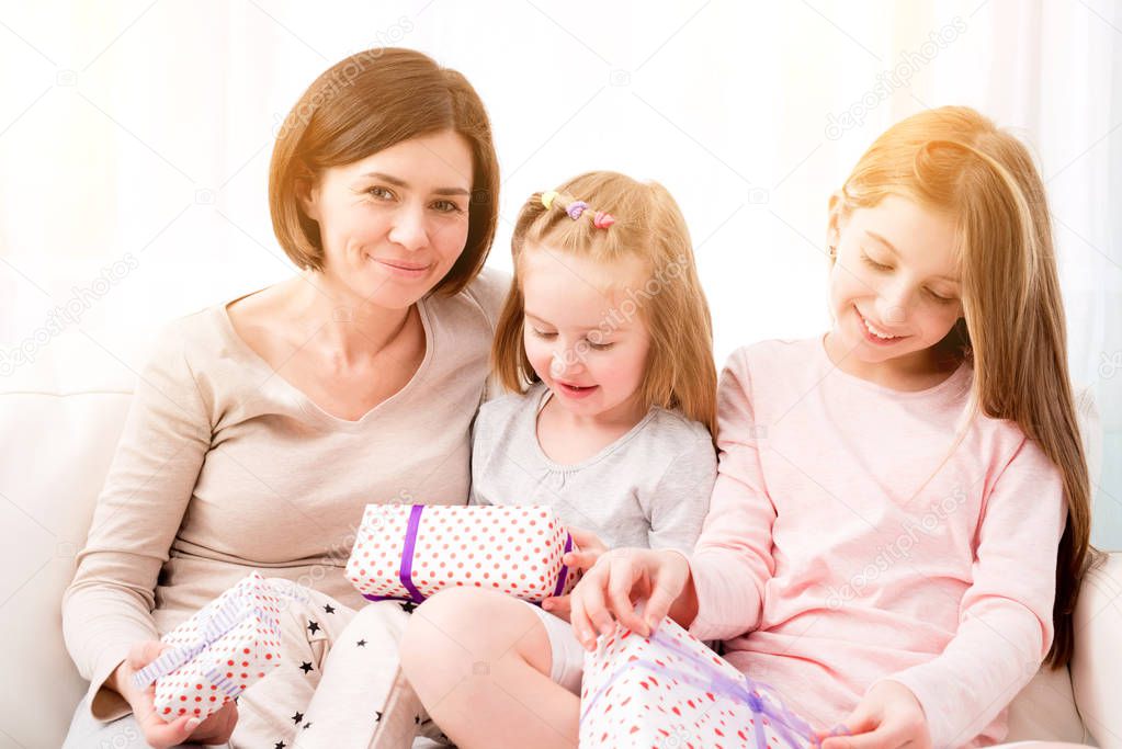 Mom and her daughters exchanging gifts