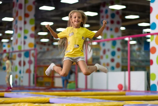 Маленькая взволнованная девочка сфотографирована во время прыжка на батуте — стоковое фото