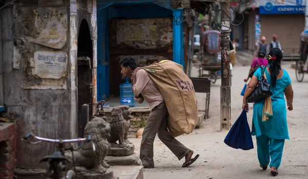 L'uomo porta un sacco sulla schiena per le strade di Kathmandu — Foto Stock