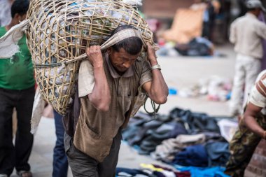 İnsan Katmandu sokaklarda sırtında bir çuval taşımak