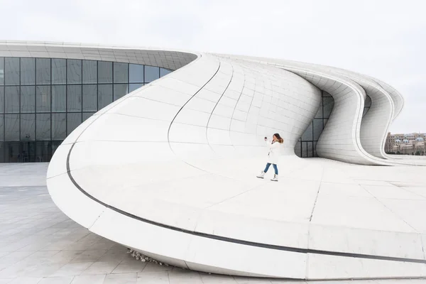 Vrouw maakt een foto in de buurt van Heydər Aliev Center — Stockfoto