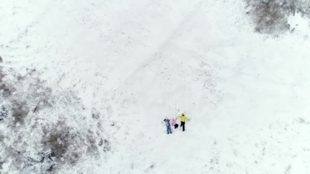 Moeder en dochters opleggen van sneeuw — Stockvideo