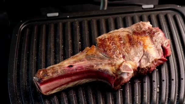 Sappig stukje biefstuk op een grill gekruid met specerijen — Stockvideo