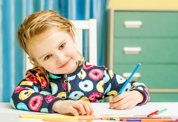 Sjarmerende blond liten jente tegner med blyanter. – stockfoto