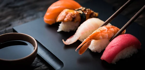 Gros plan de sashimi sushi serti de baguettes et de soja — Photo