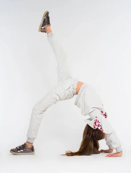 Little girl do gymnastic exercises on white background — Stock Photo, Image