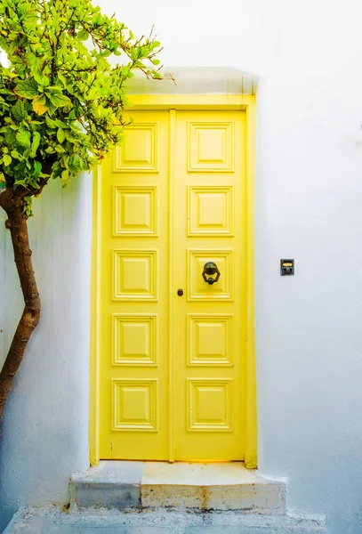 Vista frontal del edificio blanco con puerta amarilla en la calle griega — Foto de Stock