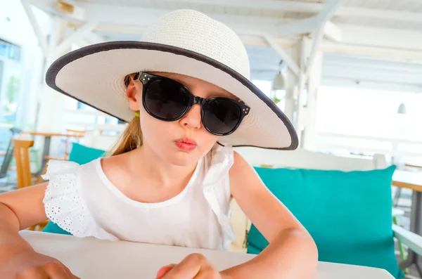 Kleines lächelndes blondes Mädchen mit schwarzer Sonnenbrille — Stockfoto