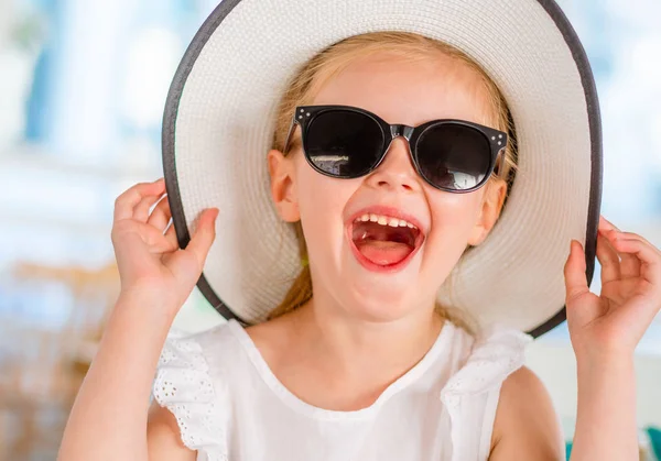 Pequeña chica rubia riendo en gafas de sol negras — Foto de Stock