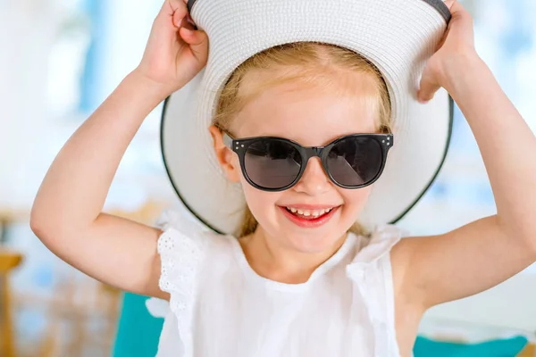 Pequeña chica rubia riendo en gafas de sol negras — Foto de Stock