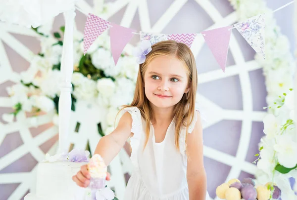 Hübsches kleines blondes Mädchen steht in der schön dekorierten Schokoriegel — Stockfoto