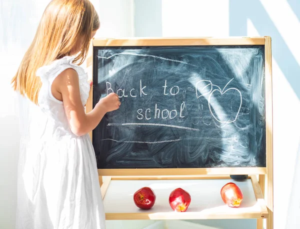 Weinig schoolage meisje puttend uit het bord — Stockfoto