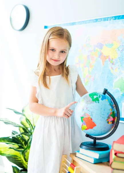 Mały schoolage dziewczyna wygląd wskazuje na całym świecie — Zdjęcie stockowe