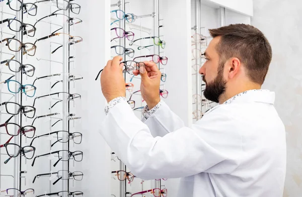 Arzt checkt Brille aus der Vitrine — Stockfoto