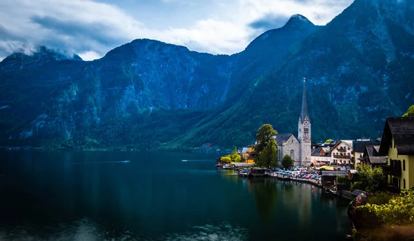 Paisaje nocturno de montañas y la ciudad de Hallstatt en el amplio lago — Foto de Stock