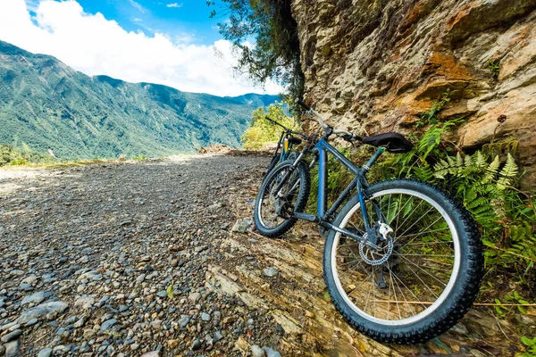 Black mountain bikes by the rock — Stock Photo, Image