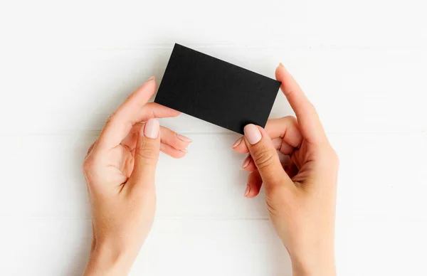 Black business card in girl hands — Stock Photo, Image