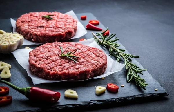 Costeletas de hambúrguer de carne crua com ingredientes — Fotografia de Stock