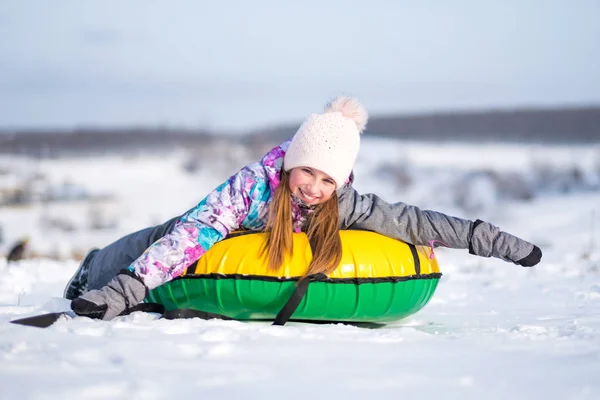 Malá holčička se těší snowtubing za slunečného počasí — Stock fotografie