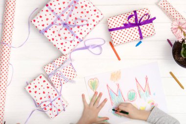 Küçük kız tebrik kartı çiziyor.