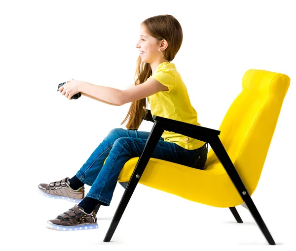 Дівчина-підліток грає з джойстиком у зручному кріслі — стокове фото
