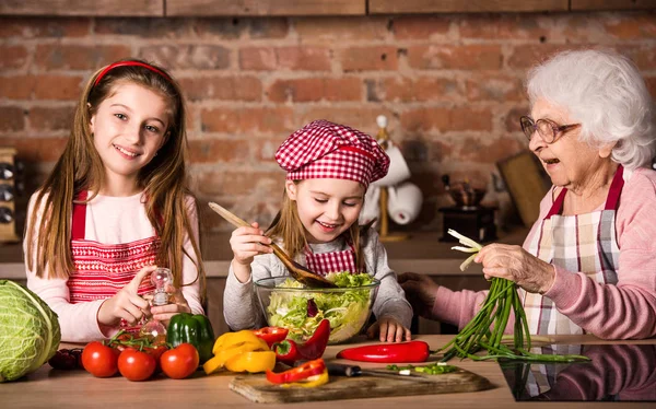 Oma en de kleinkinderen koken salade — Stockfoto