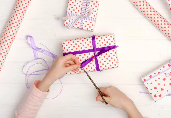 Kleines Mädchen verpackt Geschenke für den Urlaub — Stockfoto