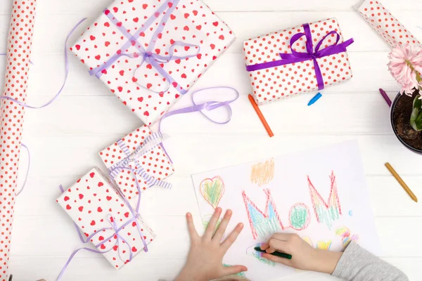 Küçük kız tebrik kartı çiziyor.