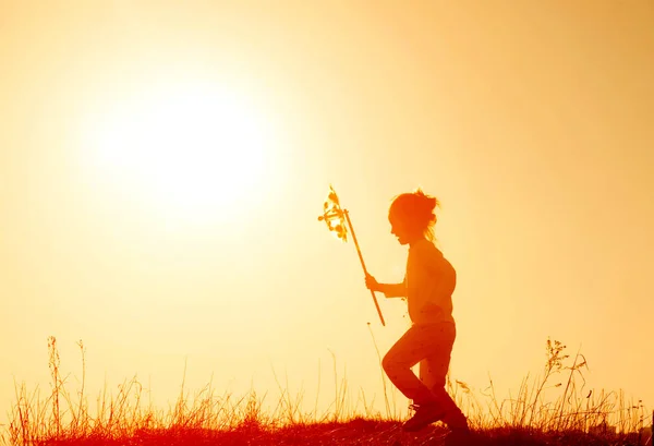 Silhouet van kind meisje met windmolen — Stockfoto