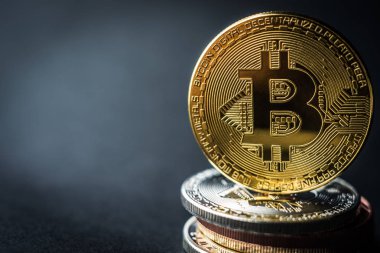 Üstünde altın para olan bitcoin yığını.