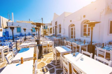 Tipik Yunan taverna renkli masa ve sandalyeler Naoussa Port ile
