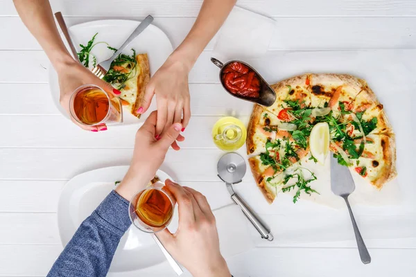 Two people shake hands while eating pizza — Stock Photo, Image