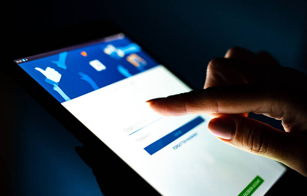 close up girl hand using tablet with Facebook app