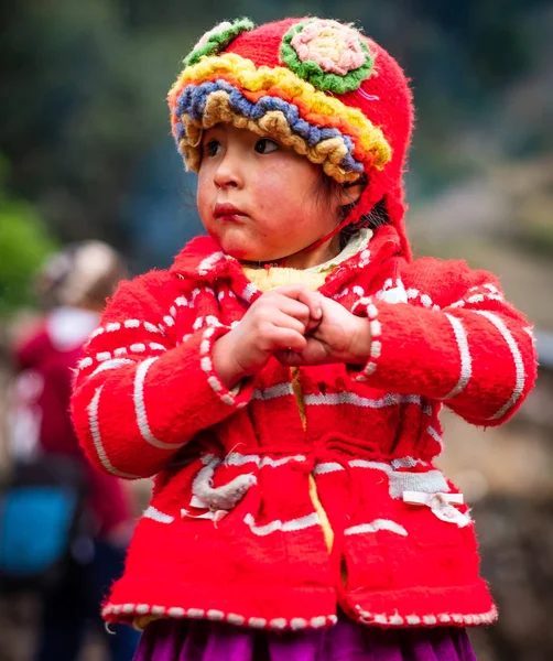 Klein meisje in rood pak en hoed op zoek, in Cusco — Stockfoto