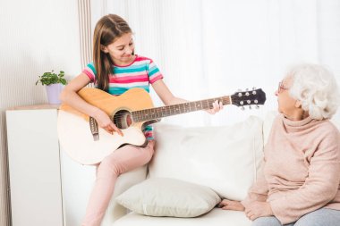 Büyükanne için gitar çalmaya torunu