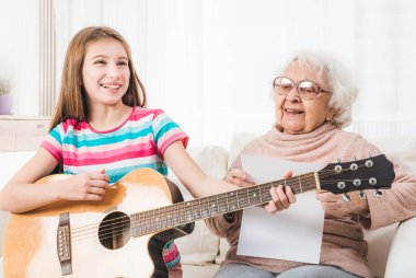 Büyükanne için gitar çalmaya torunu