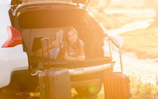 Little girl lying in a trunk of car on a travel vacation — Stock Photo, Image