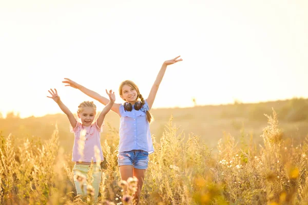 Kleine lächelnde Mädchen stehen mit freudig erhobenen Händen — Stockfoto