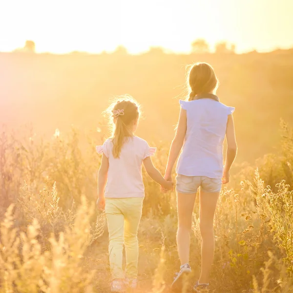 Kleine Mädchen schauen auf Sonnenschein Abendwiese — Stockfoto