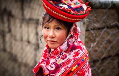 Ulusal kırmızı elbise ve şapka duvar arka planda Cusco, küçük kız