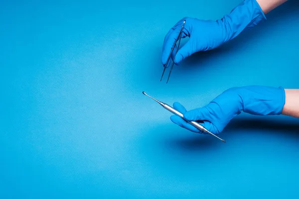 Handen in blauw handschoenen houden tandheelkunde stokken — Stockfoto